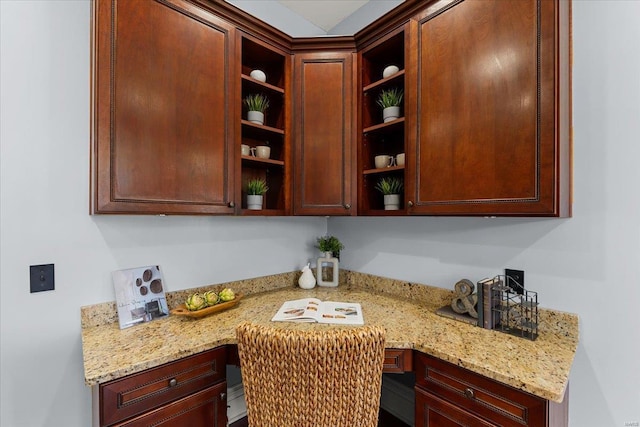 kitchen featuring open shelves, light stone countertops, and built in study area