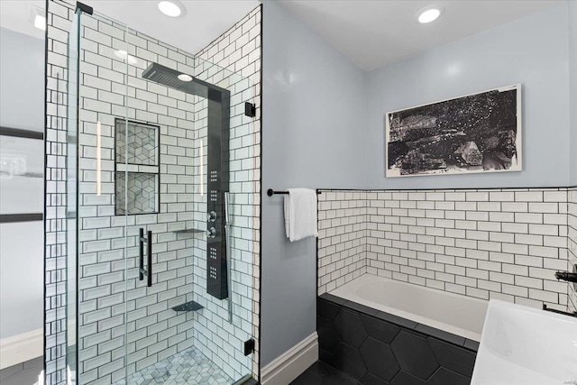 bathroom with recessed lighting, baseboards, a garden tub, and a stall shower