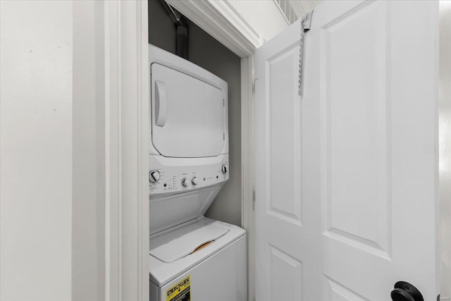 washroom with stacked washer and dryer and laundry area