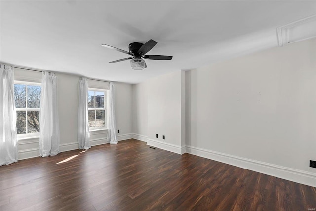 empty room featuring visible vents, a ceiling fan, baseboards, and wood finished floors