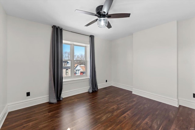 empty room with ceiling fan, baseboards, and dark wood finished floors