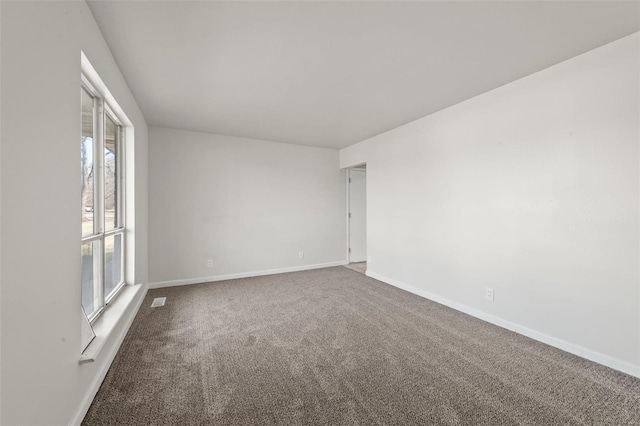 carpeted spare room with visible vents and baseboards