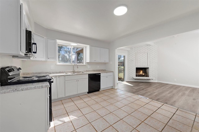 kitchen with a sink, range with electric stovetop, open floor plan, light tile patterned floors, and dishwasher