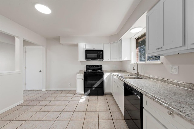 kitchen featuring black appliances, a sink, white cabinets, light tile patterned floors, and baseboards