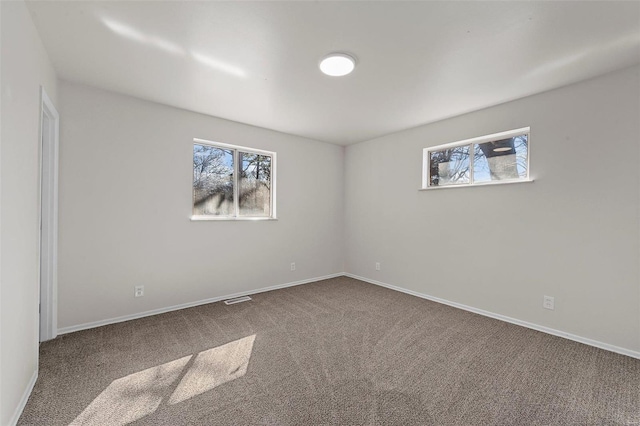 carpeted empty room featuring visible vents and baseboards