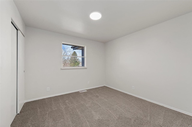 unfurnished bedroom featuring a closet, baseboards, carpet, and visible vents