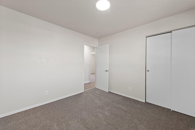 unfurnished bedroom featuring a closet, carpet flooring, and baseboards