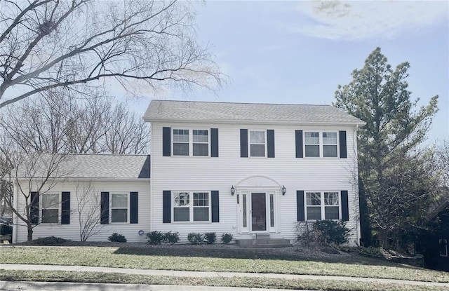 colonial house with a shingled roof and a front lawn