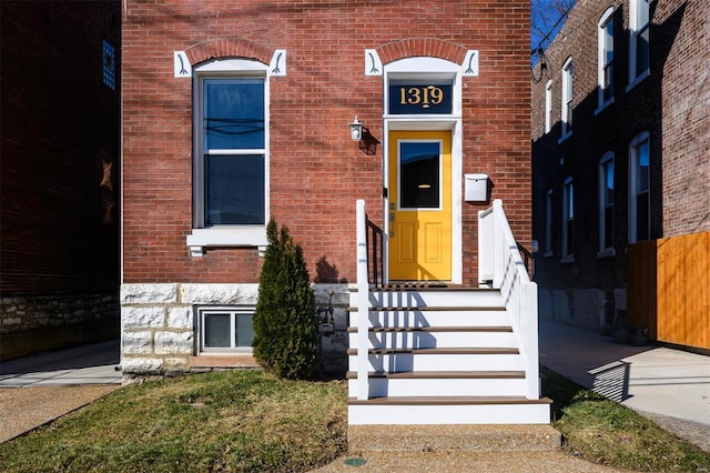 view of exterior entry featuring brick siding