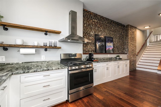 kitchen with dark wood-style floors, white cabinetry, stainless steel range with gas cooktop, and wall chimney range hood