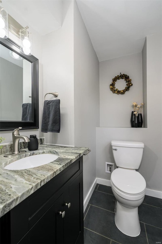 bathroom with tile patterned flooring, toilet, vanity, and baseboards