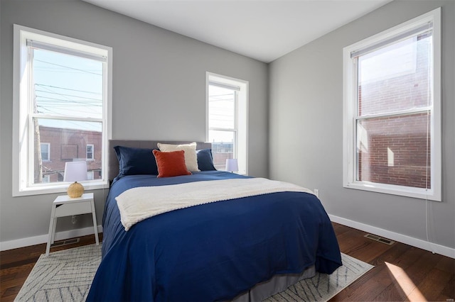 bedroom with visible vents, baseboards, and dark wood-style flooring