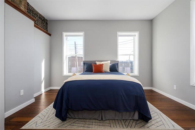 bedroom featuring baseboards and dark wood-style flooring