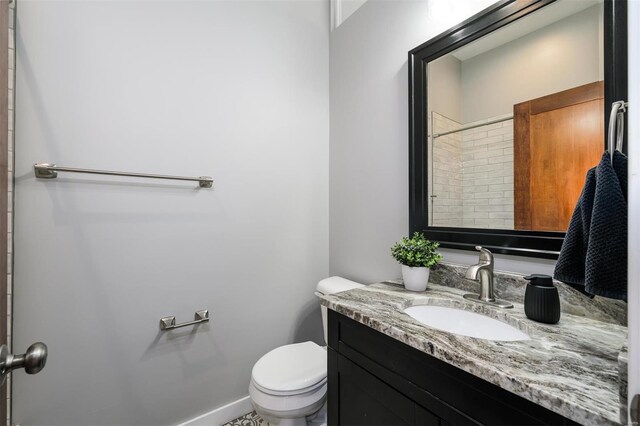 bathroom featuring toilet, vanity, and baseboards