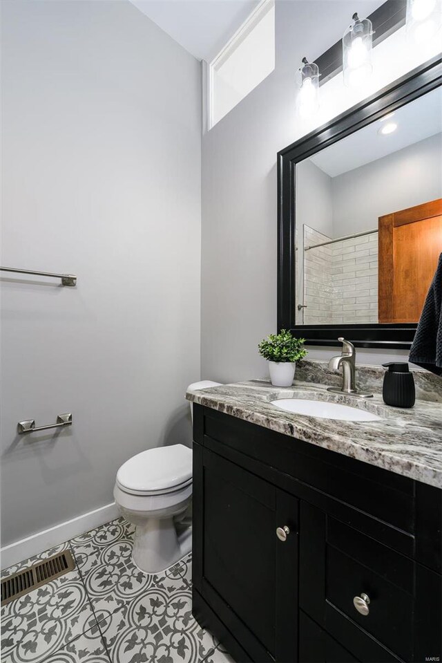 bathroom with vanity, baseboards, visible vents, tile patterned flooring, and toilet