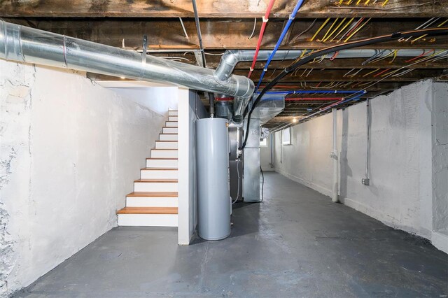 below grade area featuring water heater, stairway, and heating unit