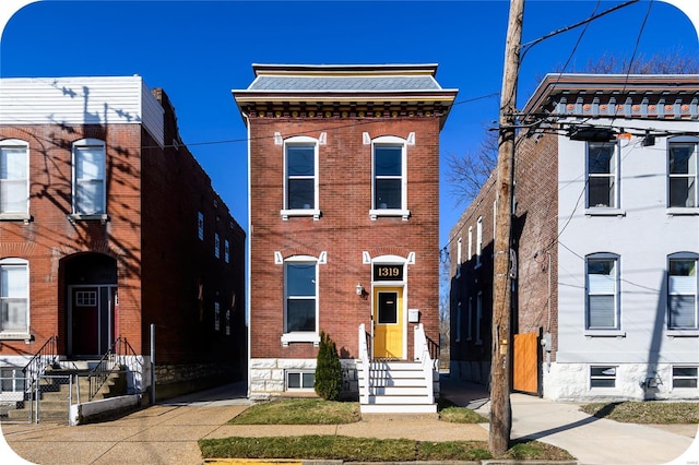 view of front facade featuring brick siding and fence