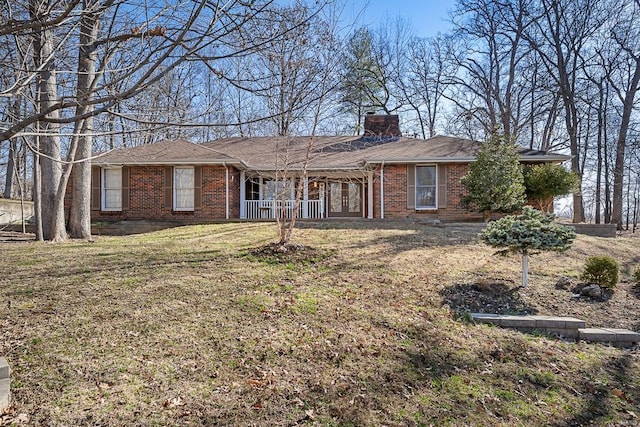 single story home with a front yard, brick siding, and a chimney