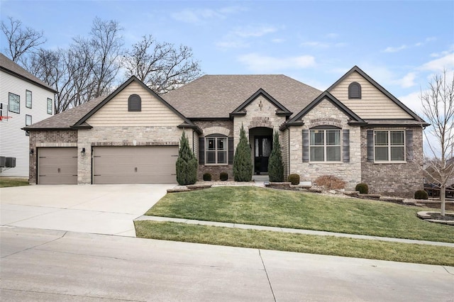 french country style house featuring brick siding, a front yard, roof with shingles, driveway, and an attached garage