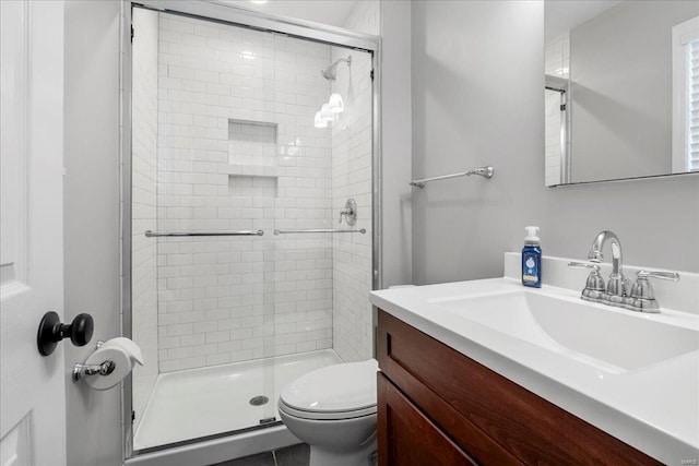 bathroom featuring a stall shower, toilet, and vanity