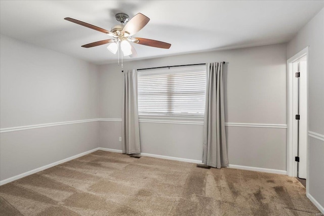 unfurnished room with carpet flooring, baseboards, and a ceiling fan