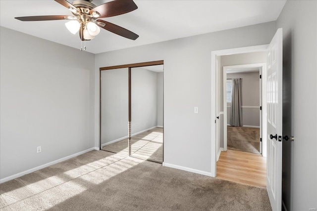 unfurnished bedroom with a closet, light carpet, baseboards, and a ceiling fan