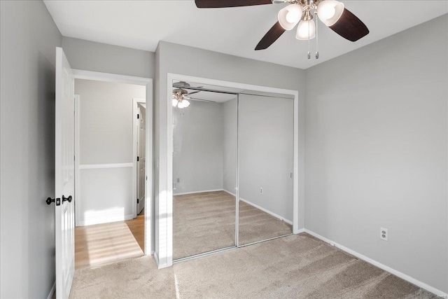 unfurnished bedroom with a ceiling fan, baseboards, a closet, and carpet floors