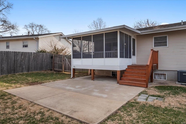 rear view of house featuring fence, a yard, a sunroom, central air condition unit, and a patio area