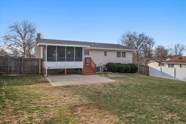 rear view of house with a yard, a patio, a fenced backyard, and a sunroom