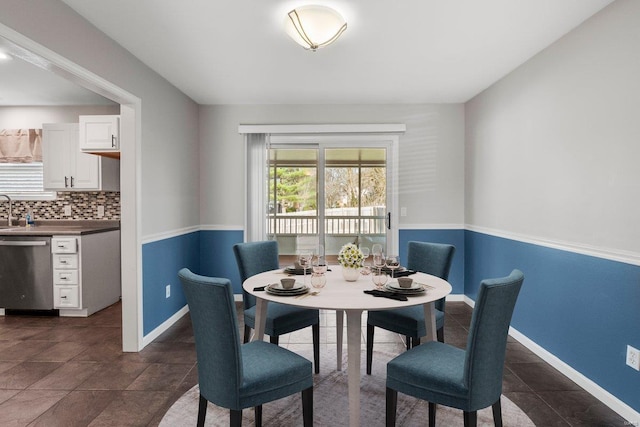 dining space with baseboards and dark tile patterned floors