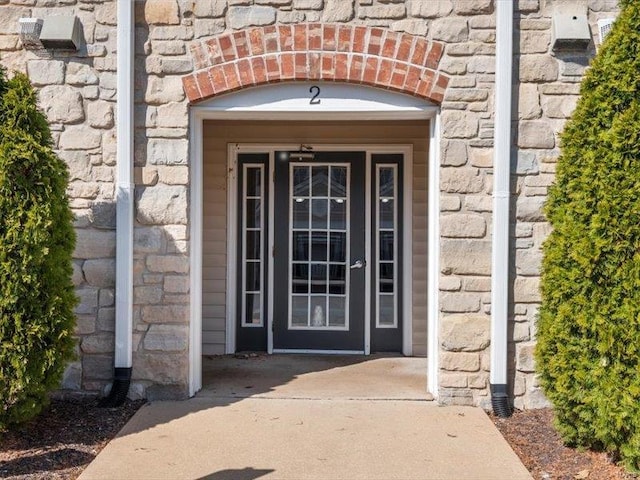 property entrance with brick siding and stone siding