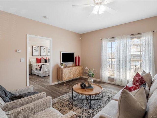 living room with baseboards, wood finished floors, and a ceiling fan