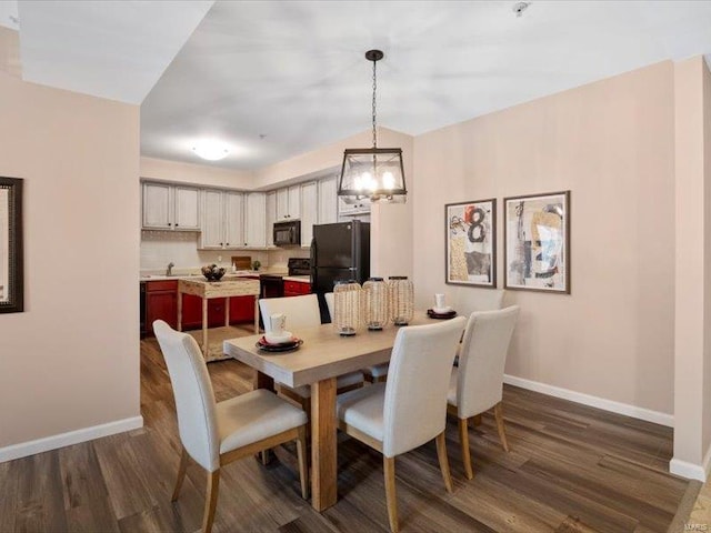 dining room featuring dark wood finished floors and baseboards