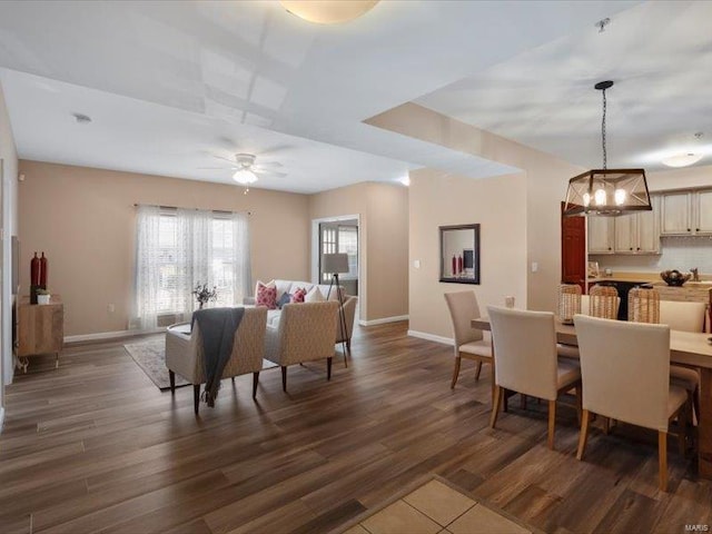 dining room featuring dark wood finished floors, baseboards, and ceiling fan