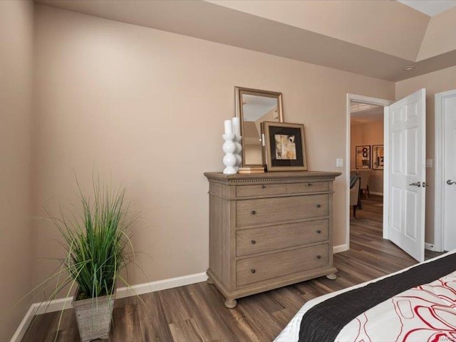 bedroom with baseboards and dark wood-type flooring