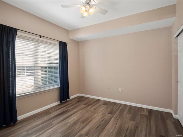 empty room featuring a ceiling fan, wood finished floors, and baseboards