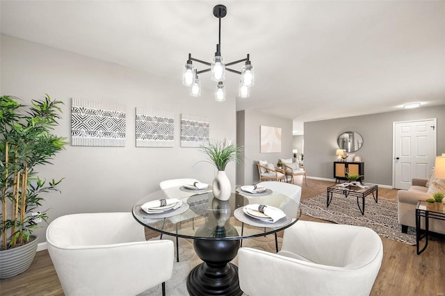 dining space with wood finished floors, baseboards, and a chandelier