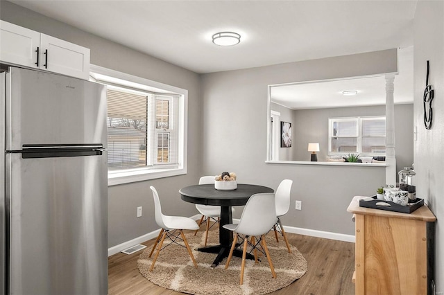 dining room with visible vents, light wood-type flooring, and baseboards