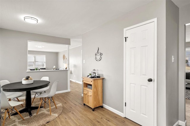 dining room featuring light wood-style floors and baseboards