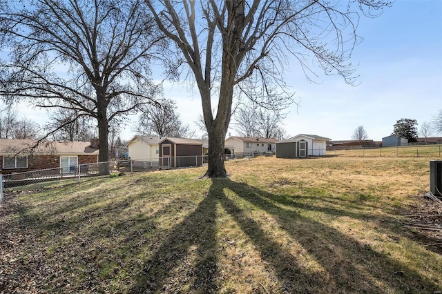 view of yard with a storage unit, an outbuilding, and a fenced backyard