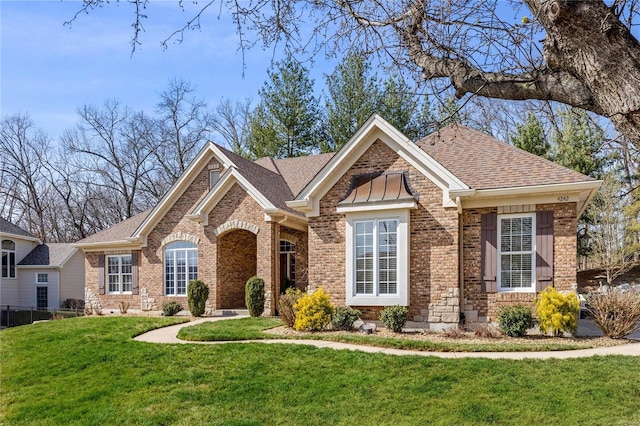 view of front of property with brick siding, roof with shingles, and a front yard