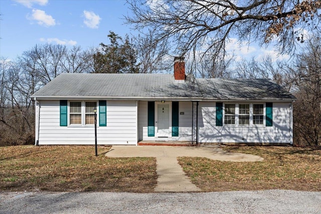 ranch-style home featuring covered porch and a chimney