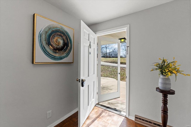 doorway with baseboards and wood finished floors