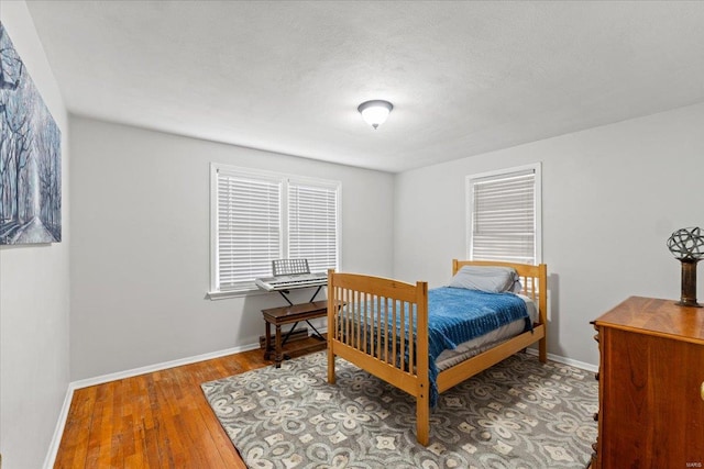 bedroom featuring baseboards and wood finished floors