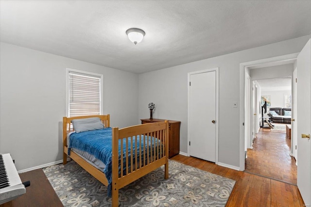 bedroom with baseboards and wood finished floors