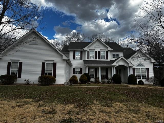 traditional-style home featuring a front yard