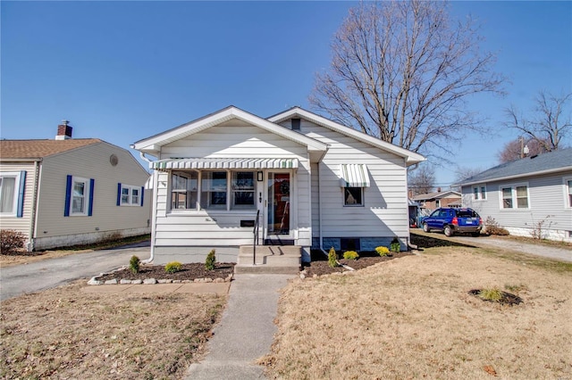 bungalow-style home with aphalt driveway