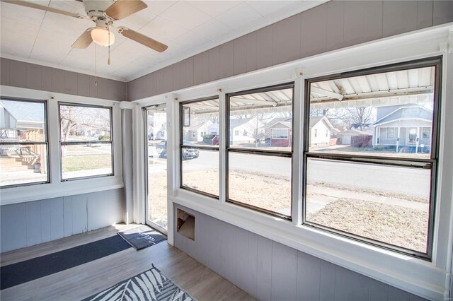 unfurnished sunroom with a ceiling fan