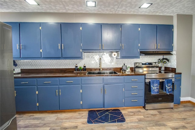 kitchen featuring blue cabinetry, under cabinet range hood, and stainless steel appliances