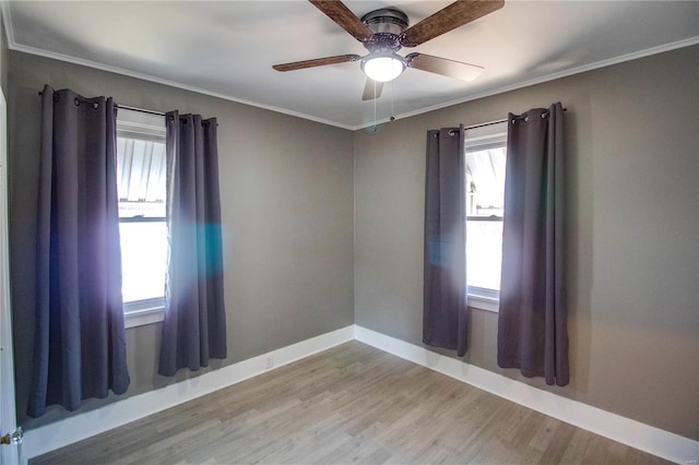 unfurnished room with ceiling fan, crown molding, baseboards, and wood finished floors